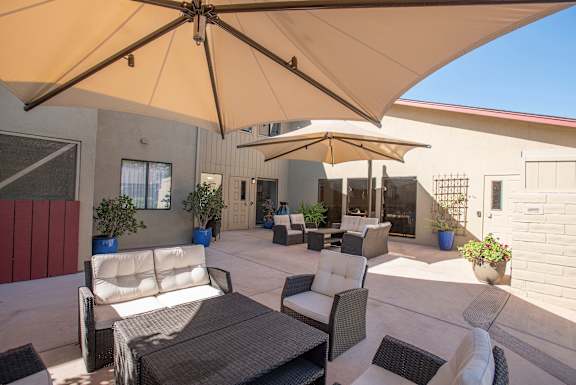 a patio with tables and chairs and umbrellas