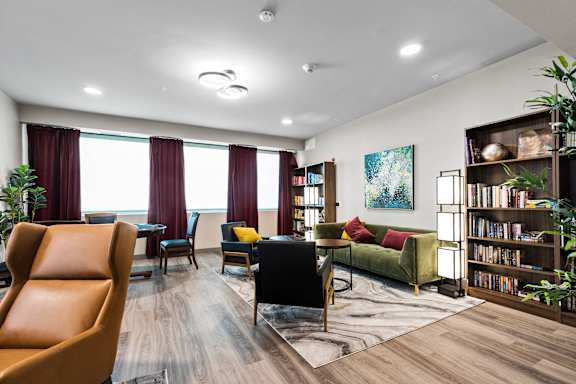 A living room with a brown leather chair and a green sofa.