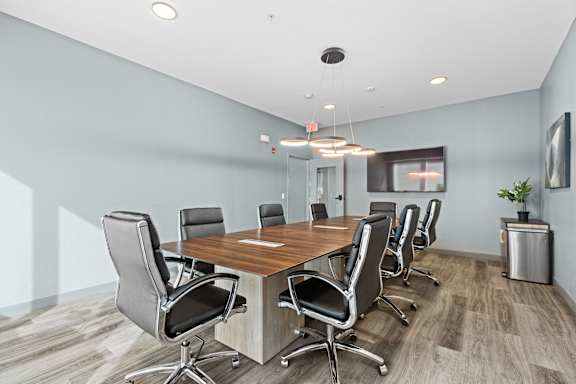 A conference room with a long table and chairs.