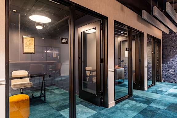 a conference room with glass doors and a blue rug