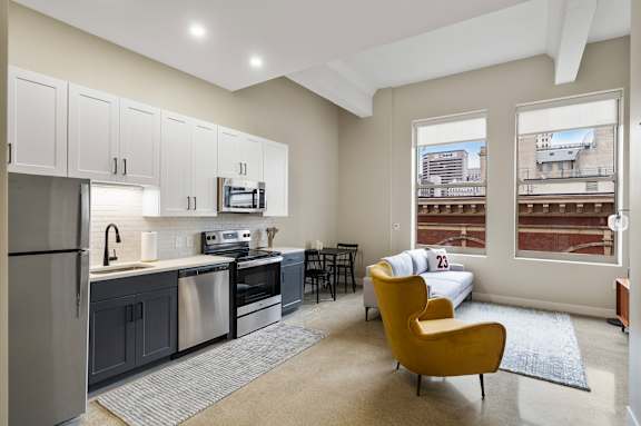 a living room with a couch and a kitchen with a sink