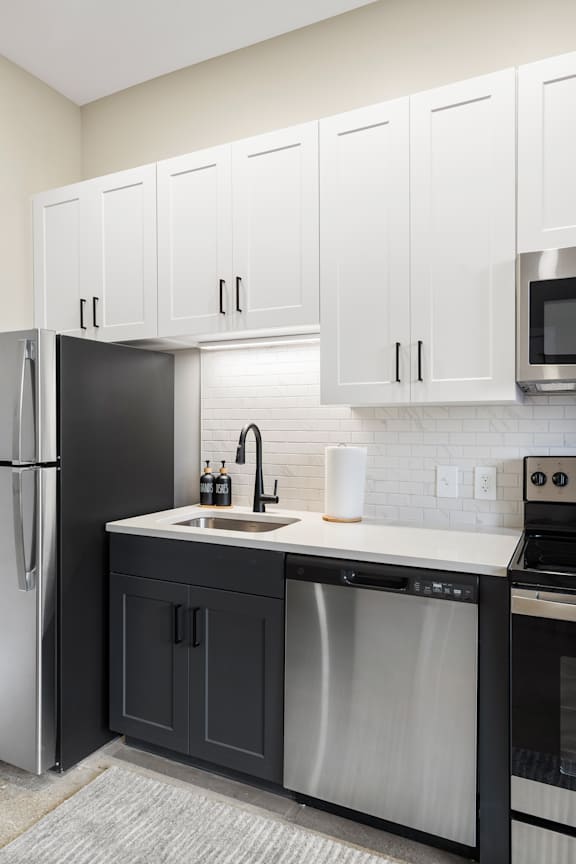 a kitchen with white cabinets and a sink and a refrigerator at Textile Apartments, Cincinnati, OH, 21286