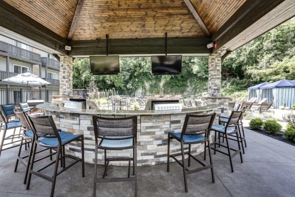 a patio with a bar and chairs at The Falls, Mission