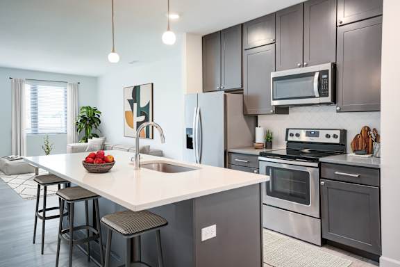 A modern kitchen with a large island and stainless steel appliances. at The MK, Indiana