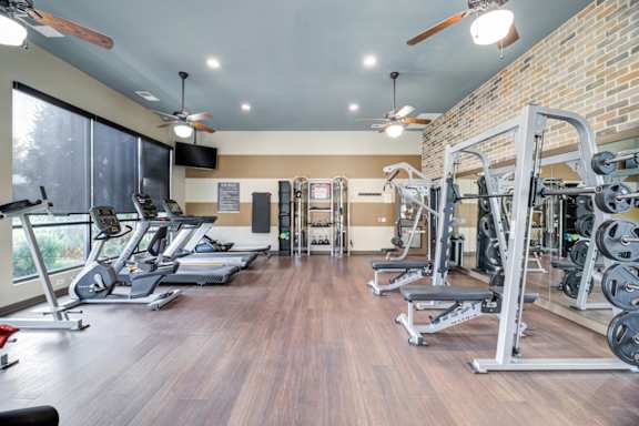 Spacious fitness center with cardio machines and weights at Adara Overland Park, Overland Park