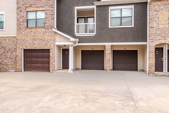 A two-story residential building with a garage on the first floor at Avenues at Shadow Creek Ranch Apartments, Pearland, Texas