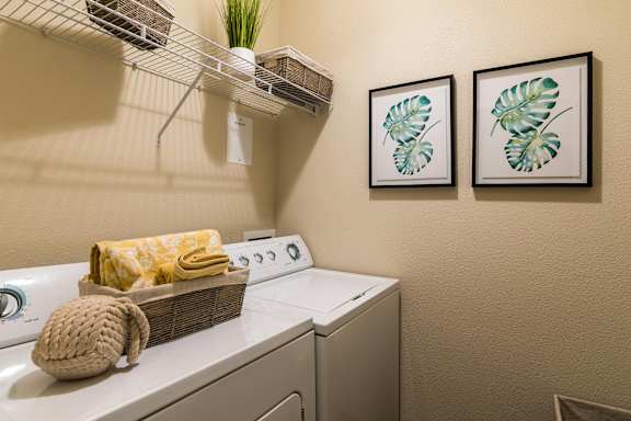 A small room with a washing machine and a basket on top of it. at CityView, North Kansas City, MO
