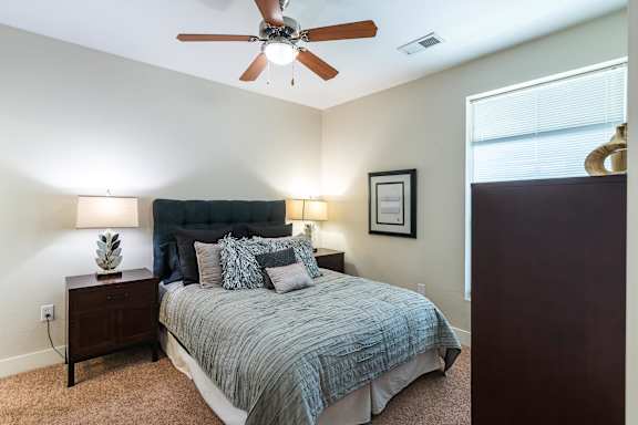 A bedroom with a bed, nightstands, and a ceiling fan. at CityView, North Kansas City, MO