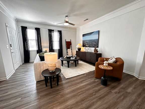 A living room with a brown chair and a white couch at Grand Villas Apartments, Katy