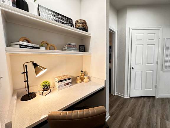 A white desk with a brown chair and a lamp on it.