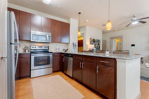 Kitchen with Brown Cabinets at Imperial Lofts, Sugar Land, TX