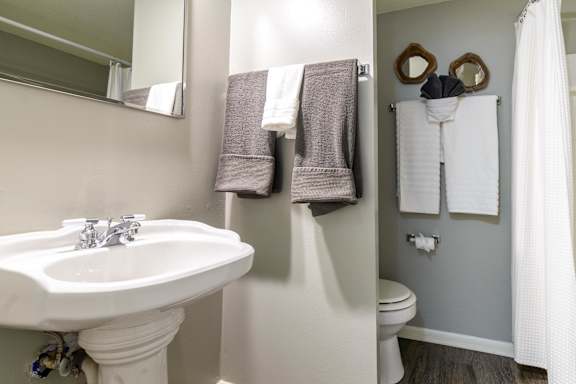 A bathroom with a white sink and toilet. at London House Apartments, Lenexa, KS, 66215