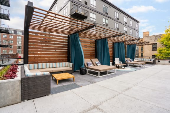 an outdoor patio with couches and chairs and a wooden canopy at Marquee, Minnesota