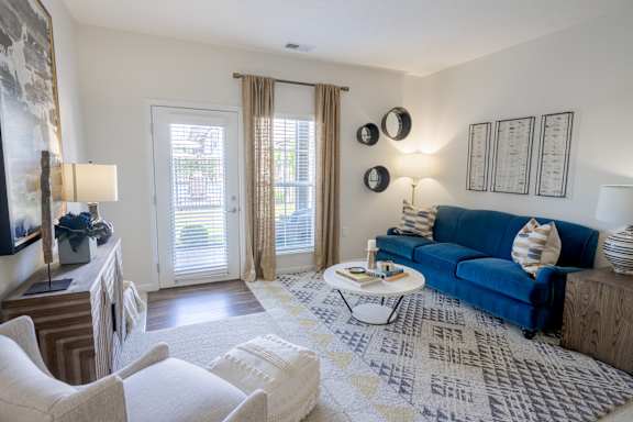 A living room with a blue couch and a coffee table. at Overland Park, Ohio