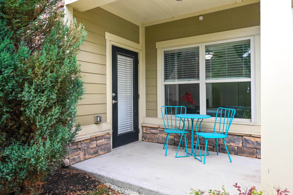 a patio with blue chairs and a table and a door at Sovereign at Overland Park, Overland Park, 66213