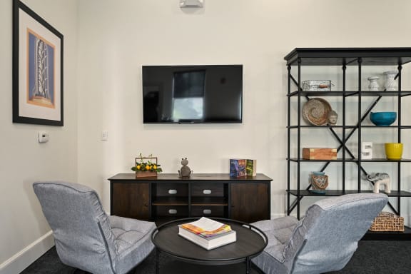 a living room with two chairs and a table and a television at Sovereign at Overland Park, Kansas, 66213