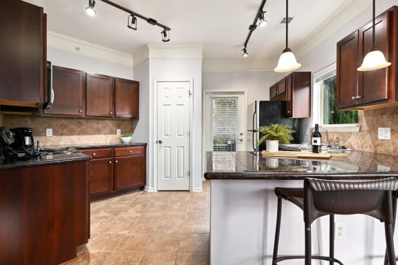 a kitchen with brown cabinets and a counter top at Sovereign at Overland Park, Kansas, 66213
