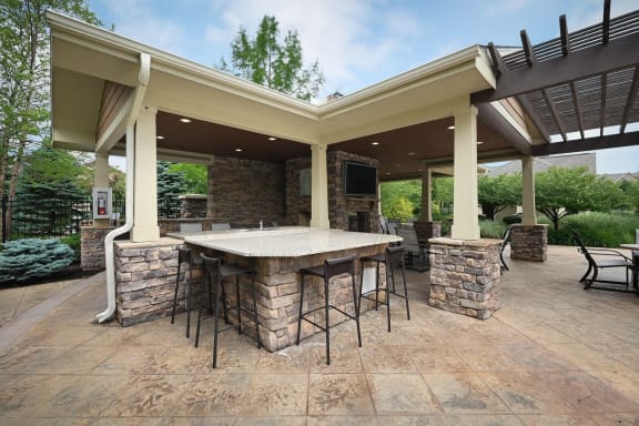 a covered patio with an outdoor kitchen and bar at Sovereign at Overland Park, Overland Park, 66213