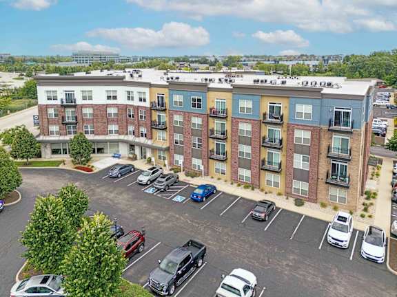 A parking lot in front of a multi-story apartment building. at Penn Circle, Carmel, Indiana