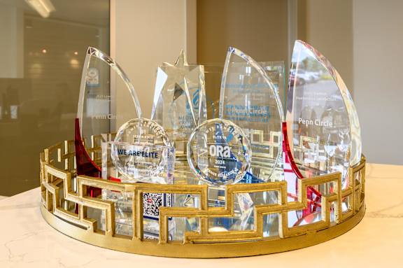 A glass trophy with a gold base and a red ribbon is displayed on a table. at Penn Circle, Carmel, 46032