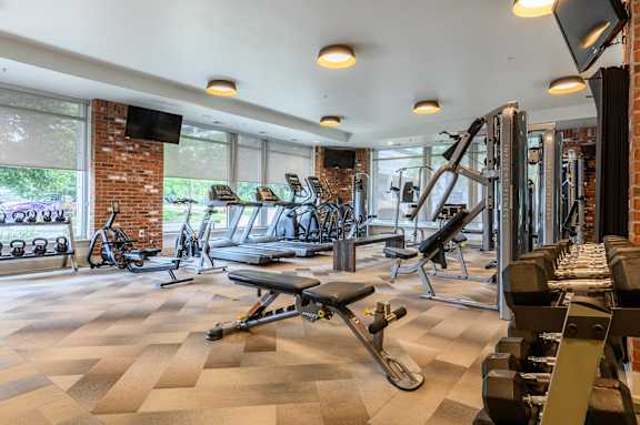 A gym with a variety of equipment including weights and cardio machines. at Penn Circle, Carmel, IN, 46032