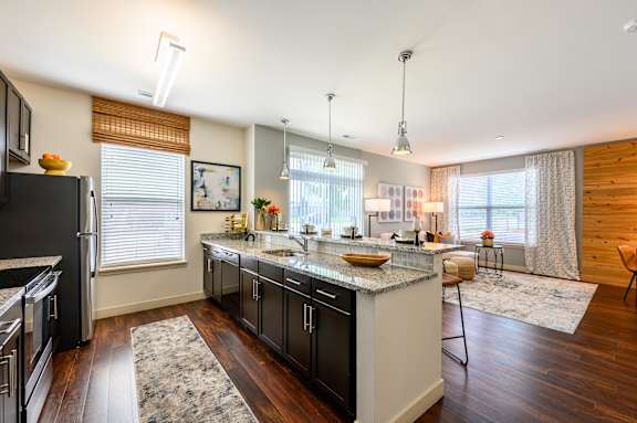 A modern kitchen with dark wood floors and stainless steel appliances. at Penn Circle, Indiana, 46032