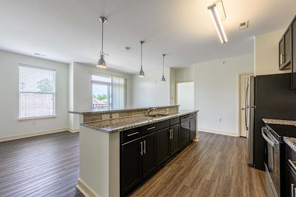 A kitchen with black cabinets and a granite countertop. at Penn Circle, Carmel, 46032