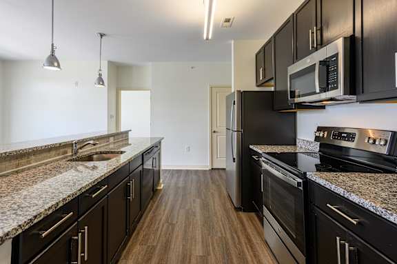 A kitchen with black cabinets and granite countertops. at Penn Circle, Carmel, Indiana