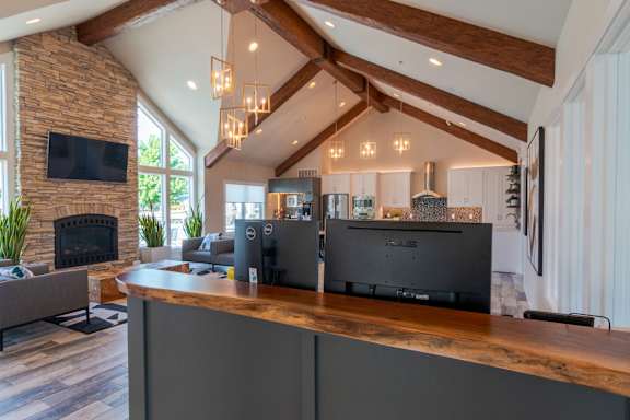 A modern kitchen with a stone fireplace and a wooden ceiling.