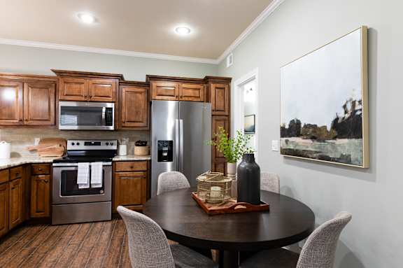 A modern kitchen with a wooden table and chairs.
