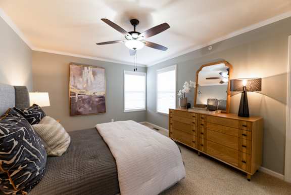 A bedroom with a bed, dresser, and mirror.