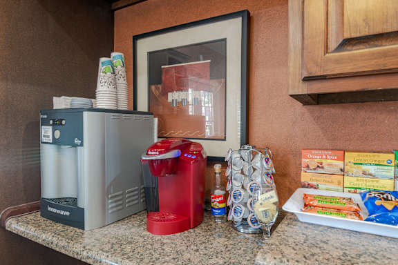 Kitchen counter with toaster, a red soda dispenser, and pack of chips at Springhill Apartments, Overland Park, Kansas