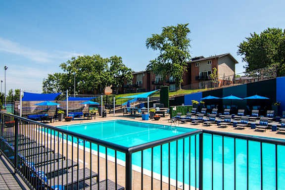 A pool surrounded by chairs and umbrellas.