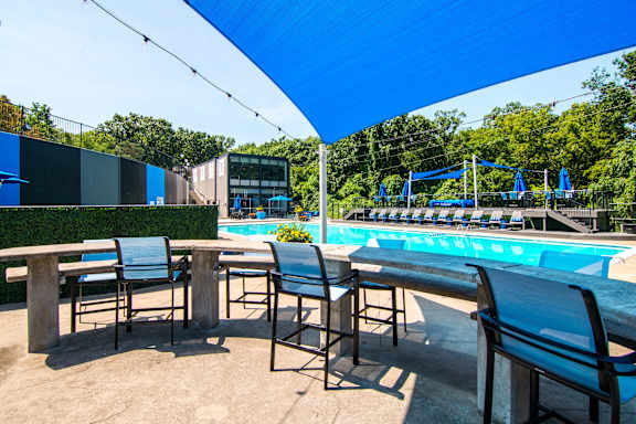 A pool area with chairs and a table.