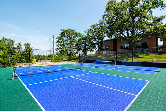 A blue tennis court with a white line down the middle.