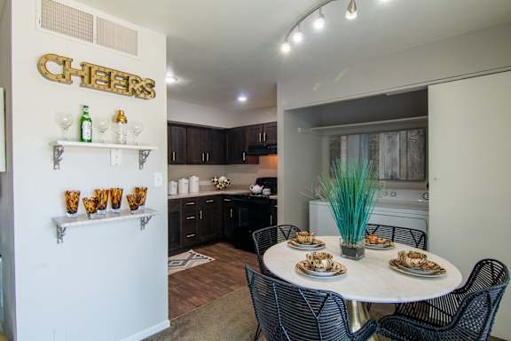 A dining area with a white table and black chairs.