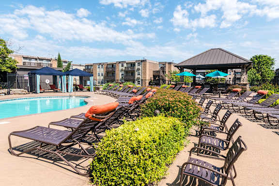 A pool area with sun loungers and a gazebo.