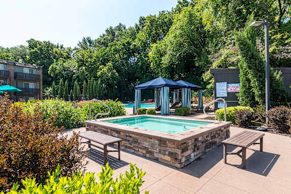 A pool area with a blue canopy and benches.