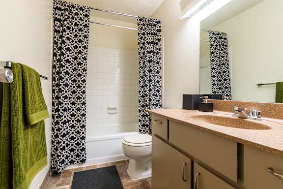 A bathroom with a toilet, sink, and shower curtain.