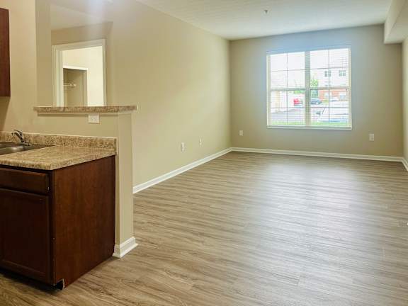 A large empty room with a sink and a window.