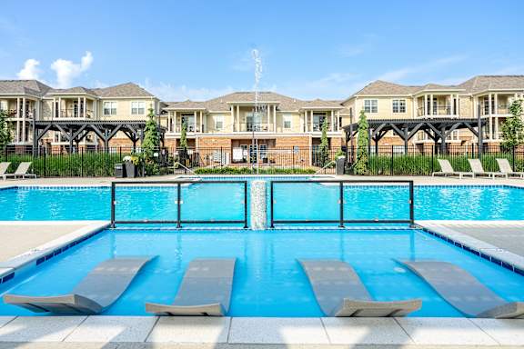 A swimming pool with lounge chairs and apartment buildings in the background. at The Greyson, Ohio, 43026