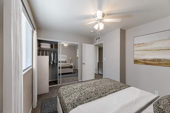 A bedroom with a bed, dresser, and mirror.