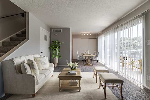 A living room with a couch, chairs, and a coffee table.