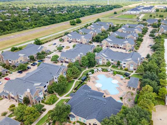 A bird's eye view of a residential area with houses and a swimming pool at Waterstone at Cinco Ranch Apartments, Katy, 77450