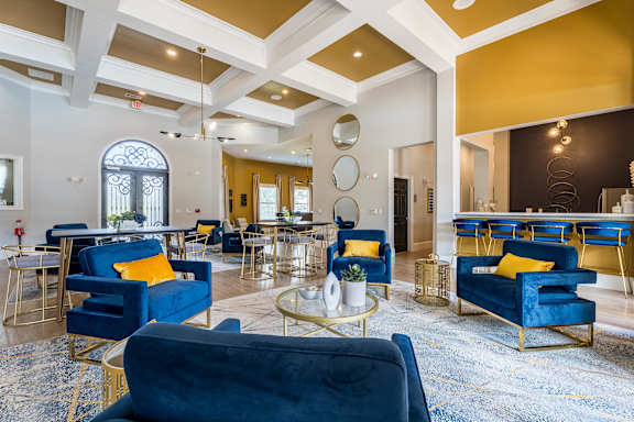 A large room with blue chairs and a gold coffee table at Waterstone at Cinco Ranch Apartments, Katy, TX