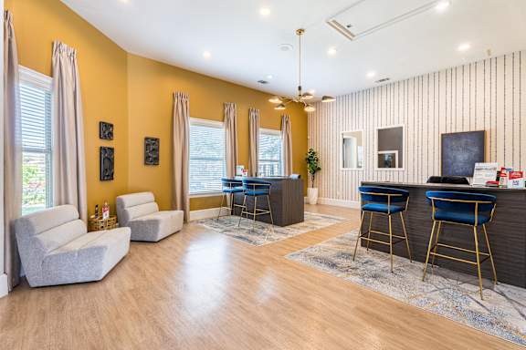 A living room with a bar area and two chairs at Waterstone at Cinco Ranch Apartments, Katy, TX 77450