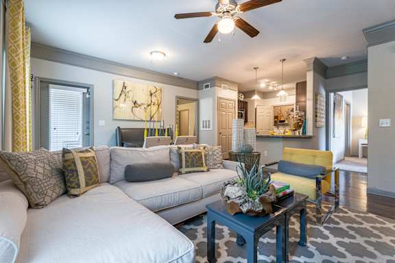 A living room with a white couch and a blue coffee table at Waterstone at Cinco Ranch Apartments, Katy, TX 77450
