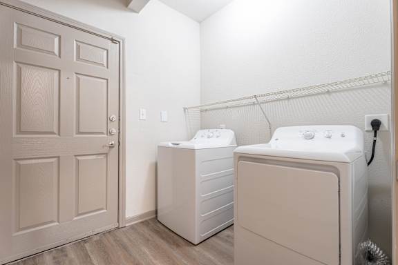 A laundry room with a washer and dryer at Waterstone at Cinco Ranch Apartments, Katy, TX