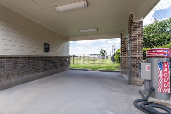 car wash bay featuring a high-powered vacuum unit and a covered washing area at Waterstone at Cinco Ranch Apartments, Katy, 77450