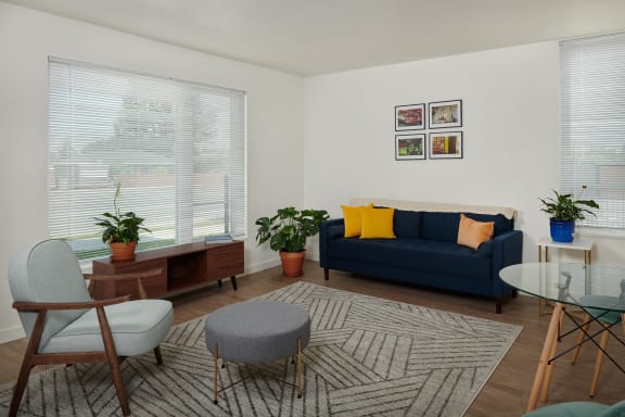 a living room with a blue couch and a table and chairs